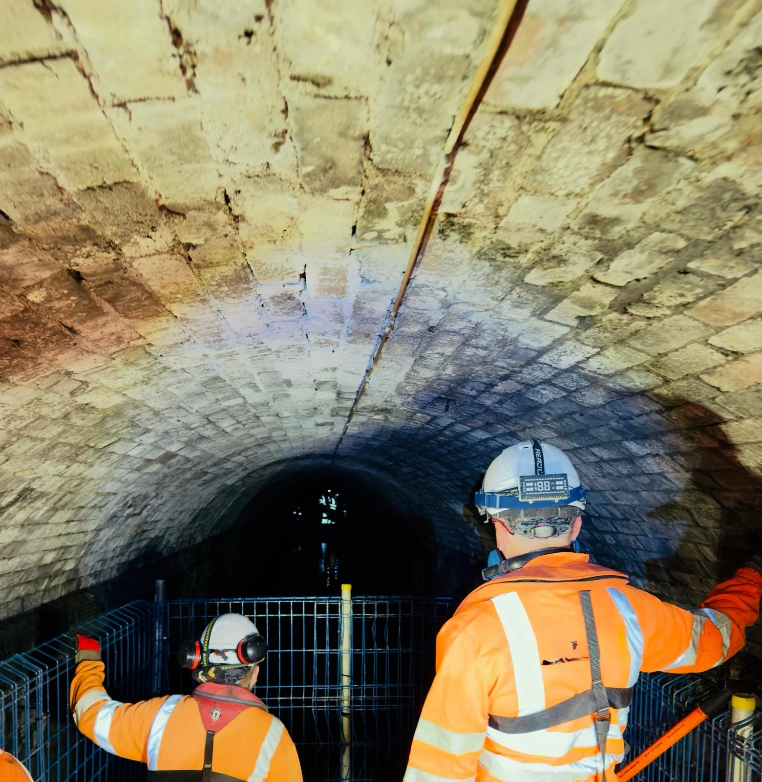 CRM confined-space operatives on a protected platform inside a masonry tunnel