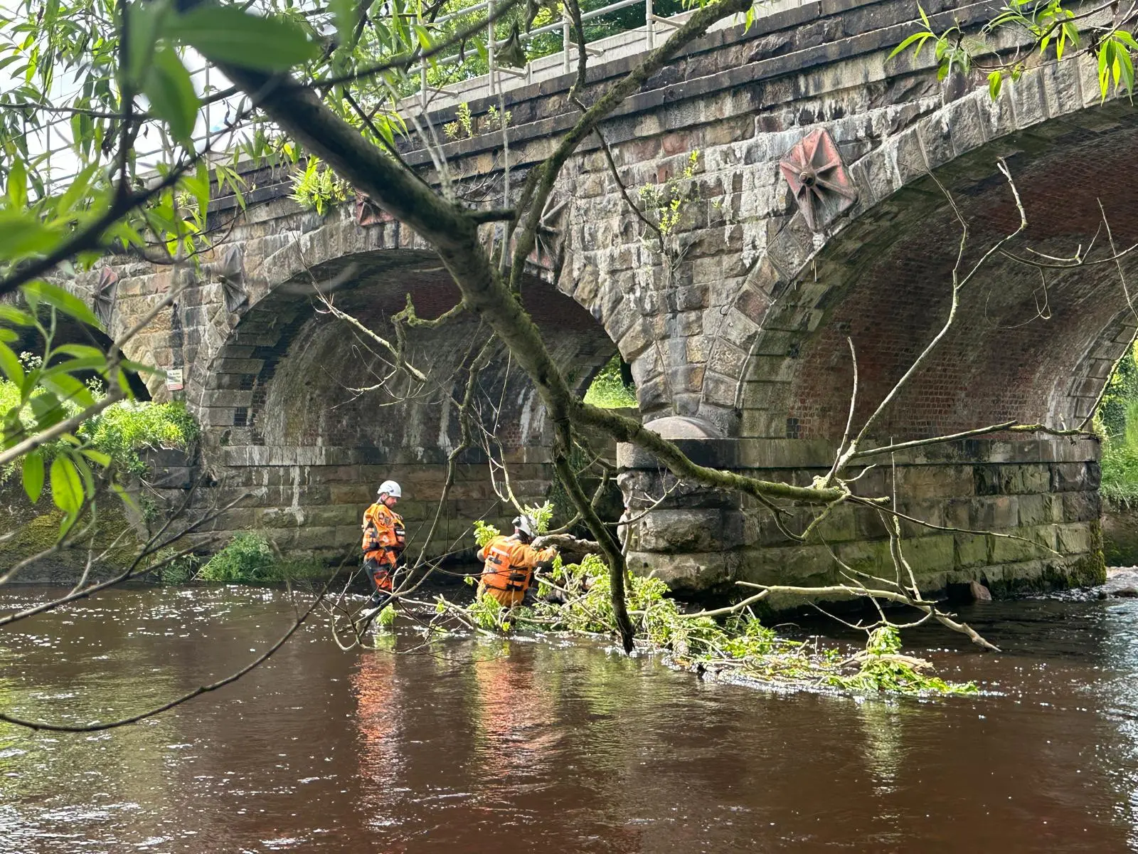 CRM operatives carrying out water-based enabling works beneath a masonry bridge